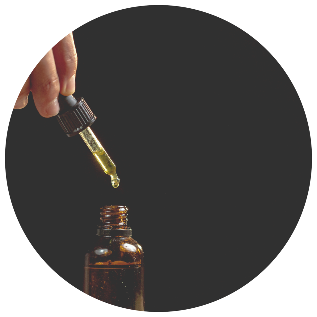 CBD Oil For Autism With Tincture Bottle And hand Holding Dropper Black Background